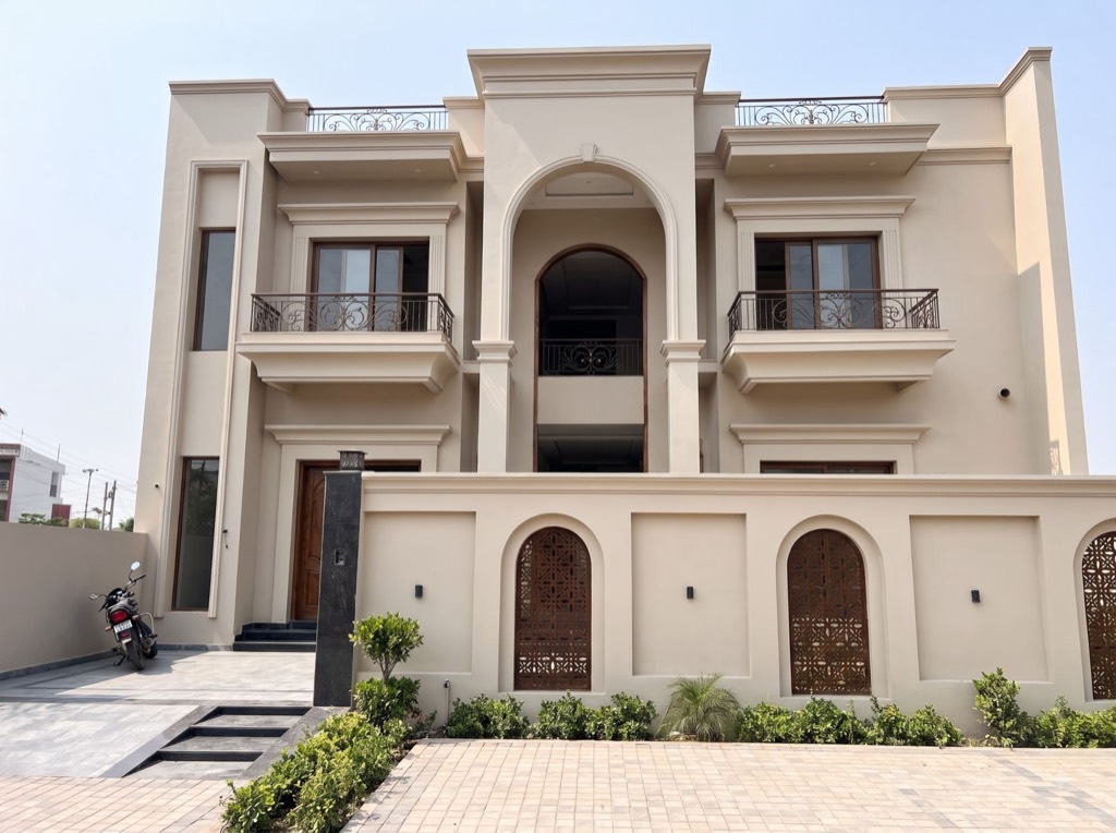Residence with a tall arched entrance and carved jaali screens